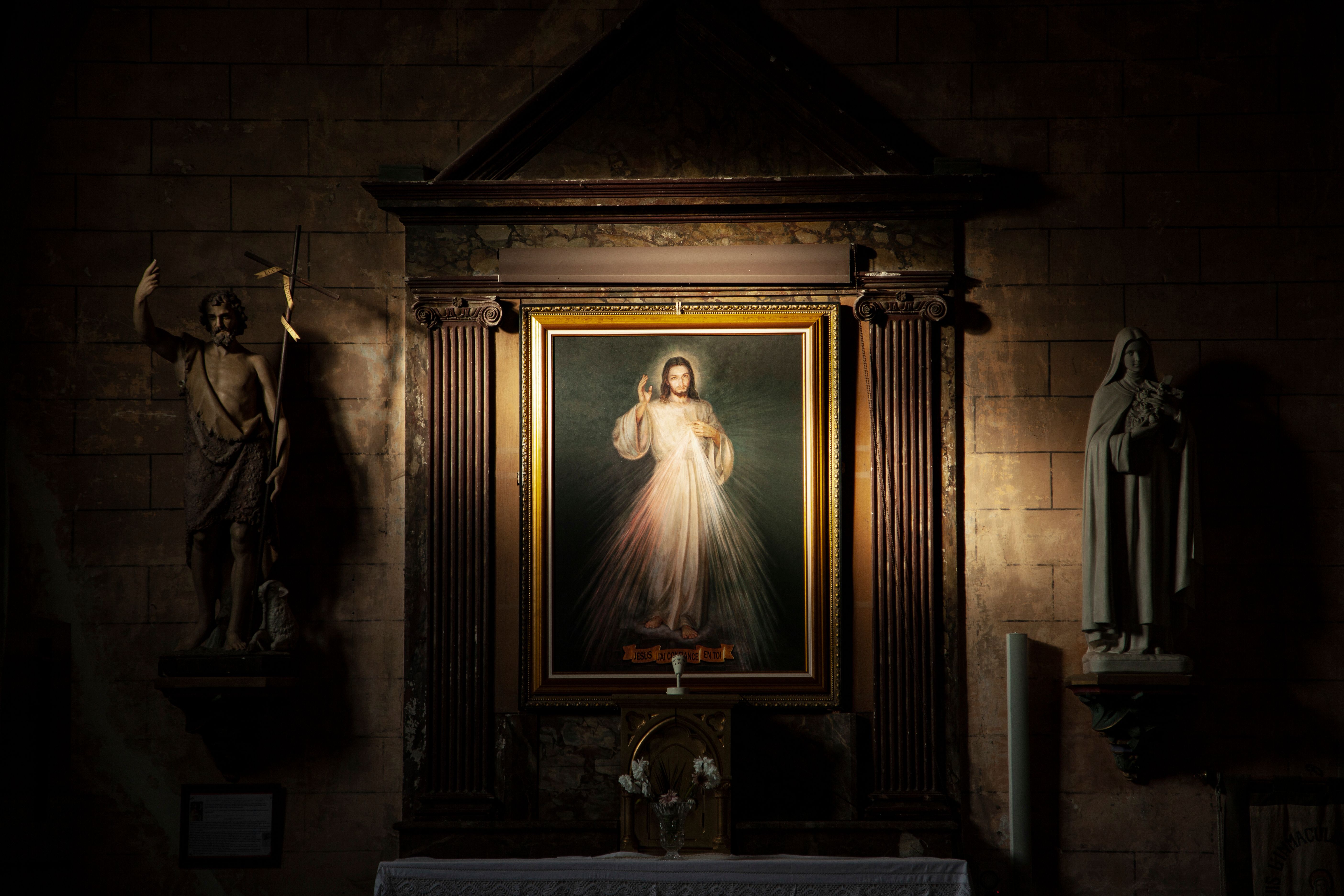 Picture of a beautiful church altar with a painting of Jesus' Divine Mercy in the background